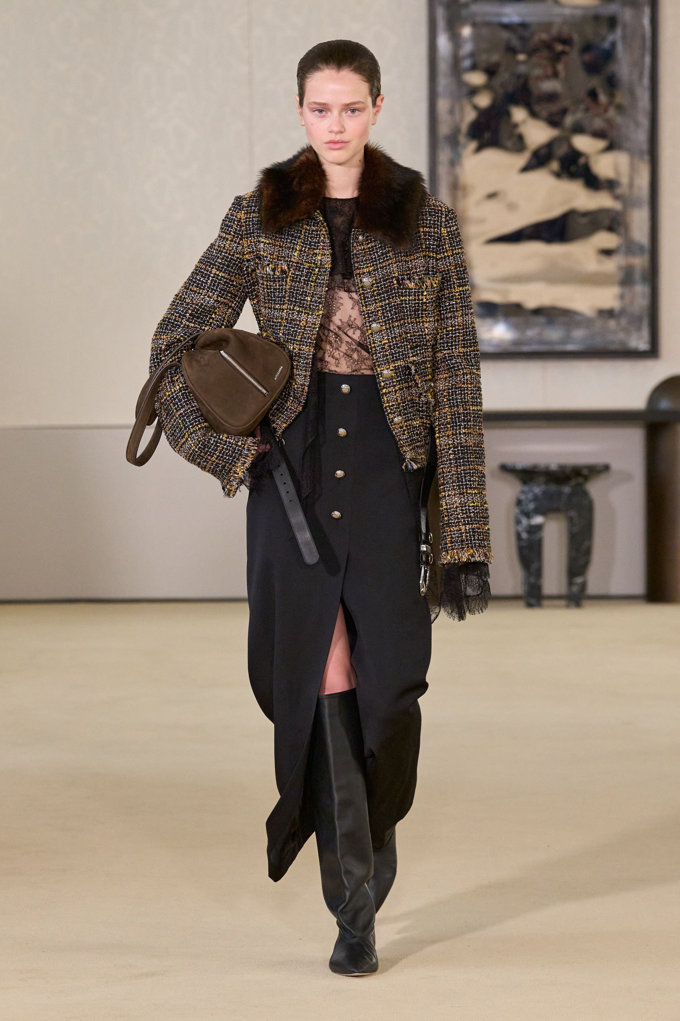 Altuzarra以克制而精准的剪裁回应都市女性的力量命题，皮革长裙、毛领外套与细节扣饰勾勒冷静轮廓，在黑棕与灰调之间展现成熟而富有策略性的优雅，将性感与权威融为一体-顽石频道趋势研究